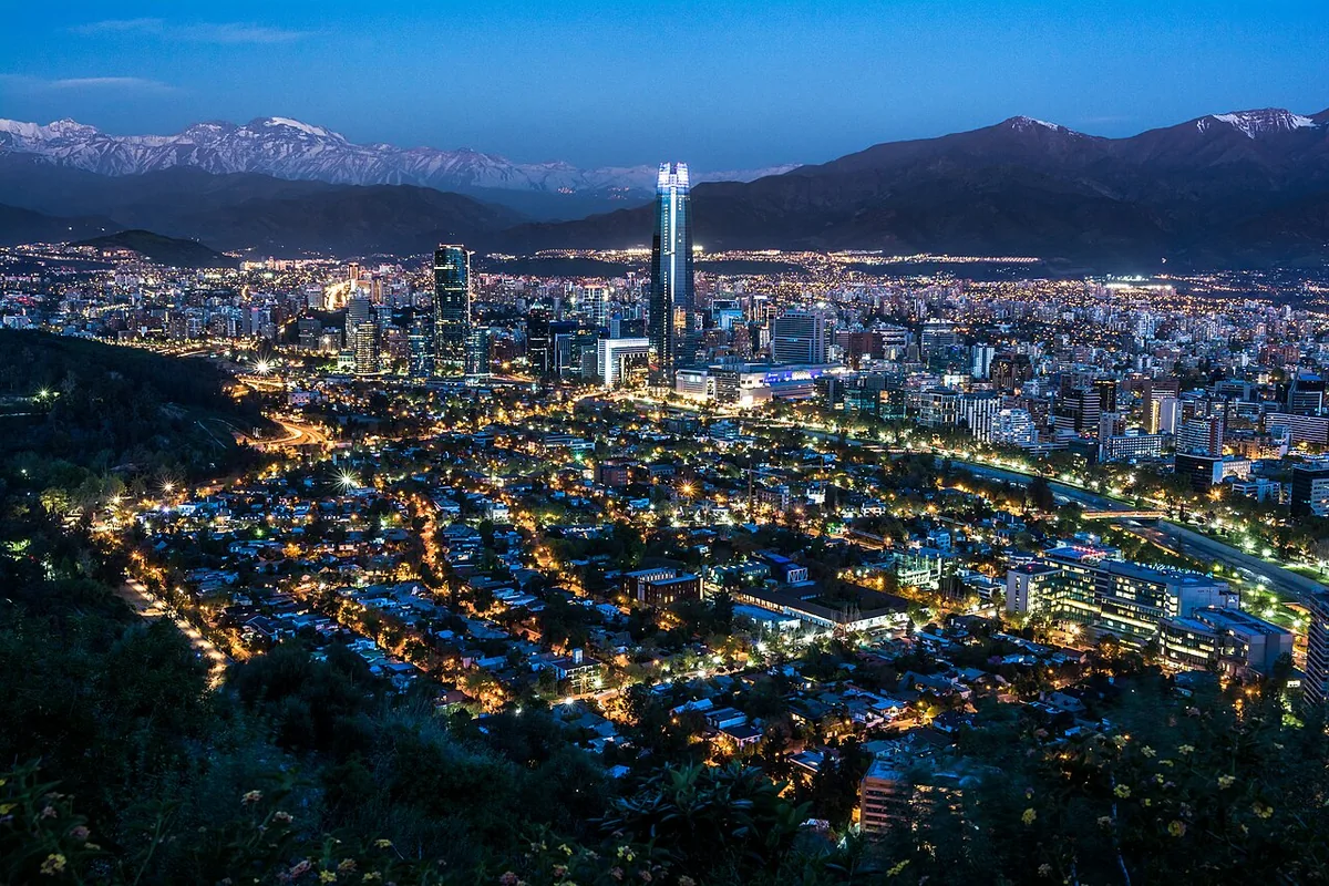 Santiago with illuminated streets and the Andes at dusk