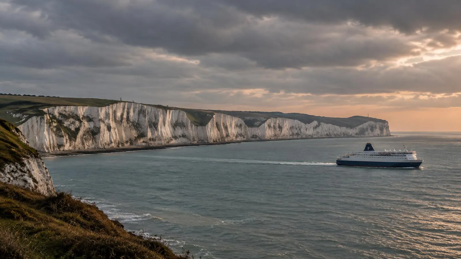 The white cliffs of Dover with a ferry in the Channel.